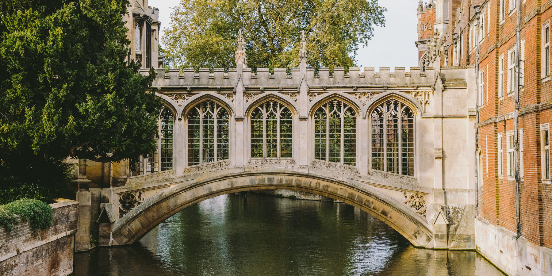 Stone bridge and college buildings over a river